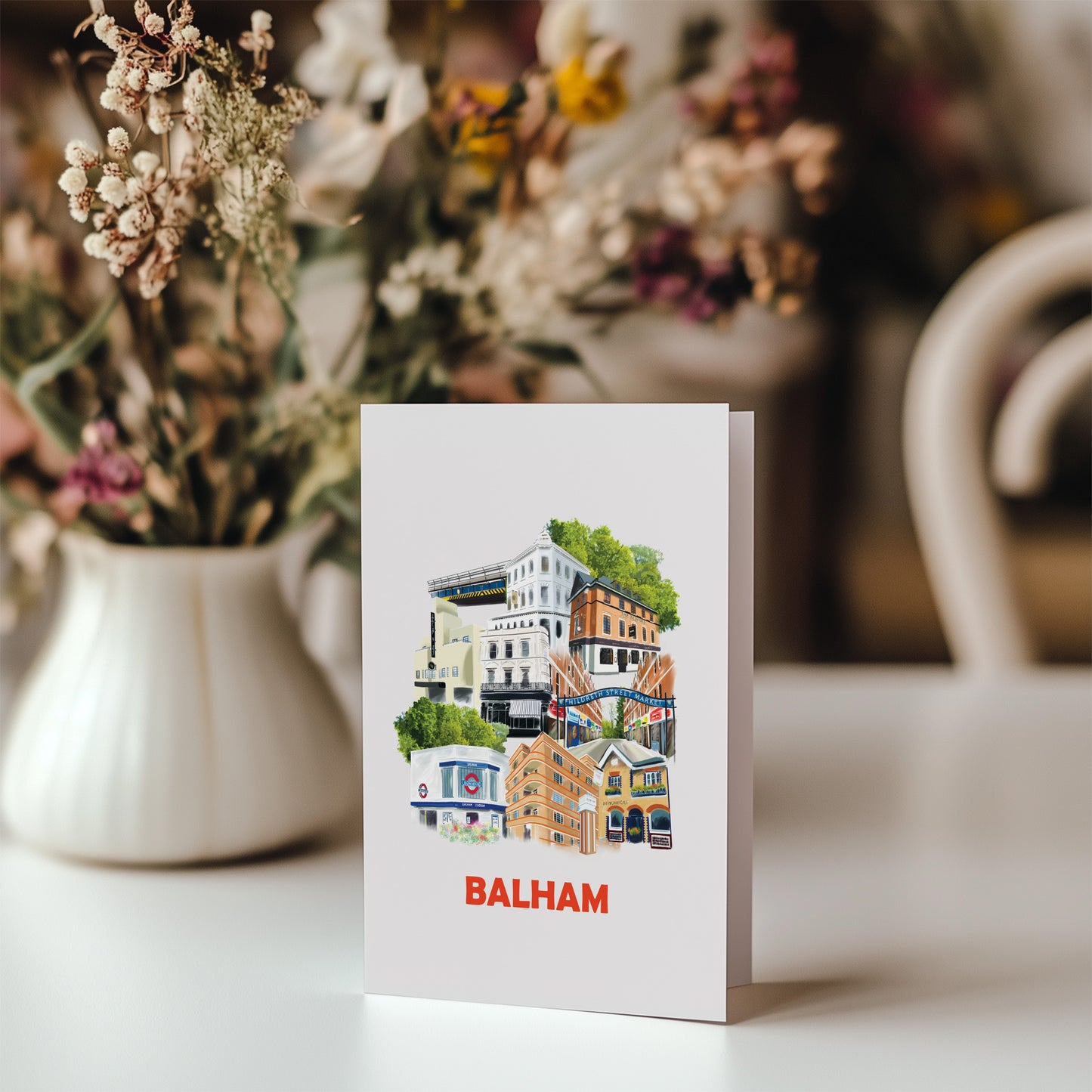 illustrations of places in Balham on a greeting card. Pictured with a bunch of flowers