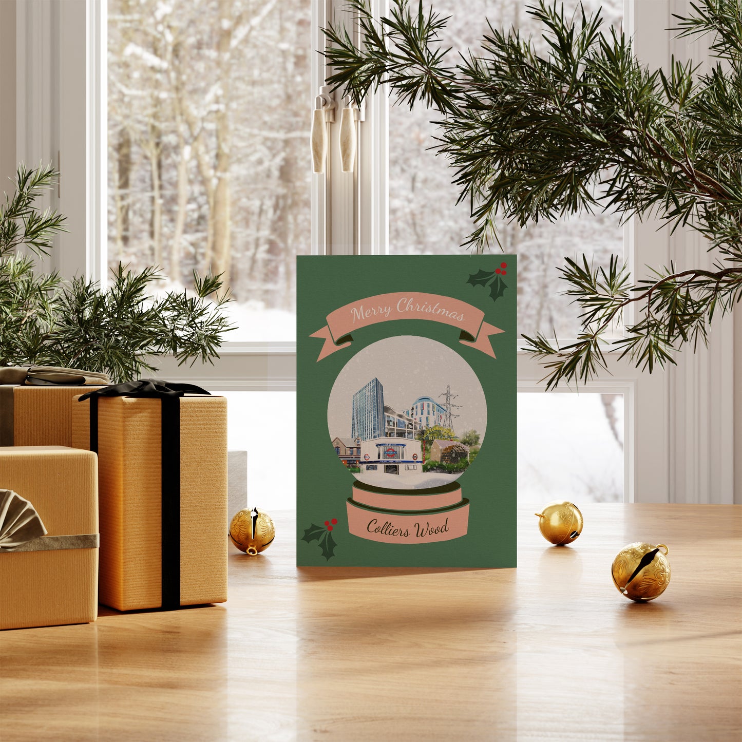Colliers Wood Christmas card with illustrations of places in Colliers Wood, London. Pictured on table with snowy scene outside.