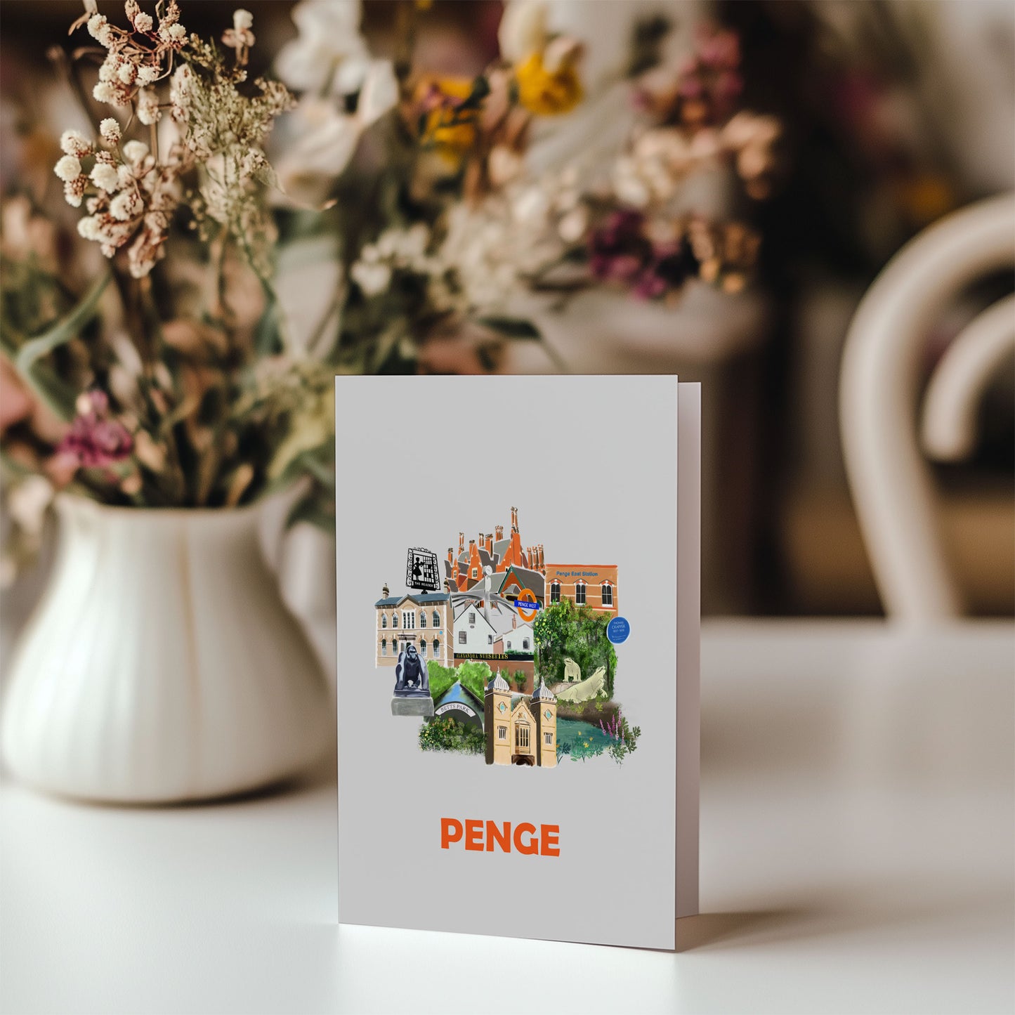 Greeting card of landmarks in Penge. Pictured on table with bunch of flowers in background