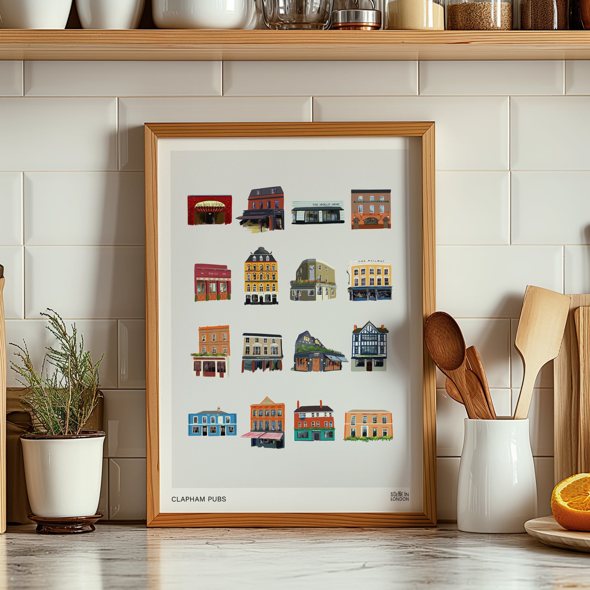 Framed artwork of Clapham pubs in a kitchen setting