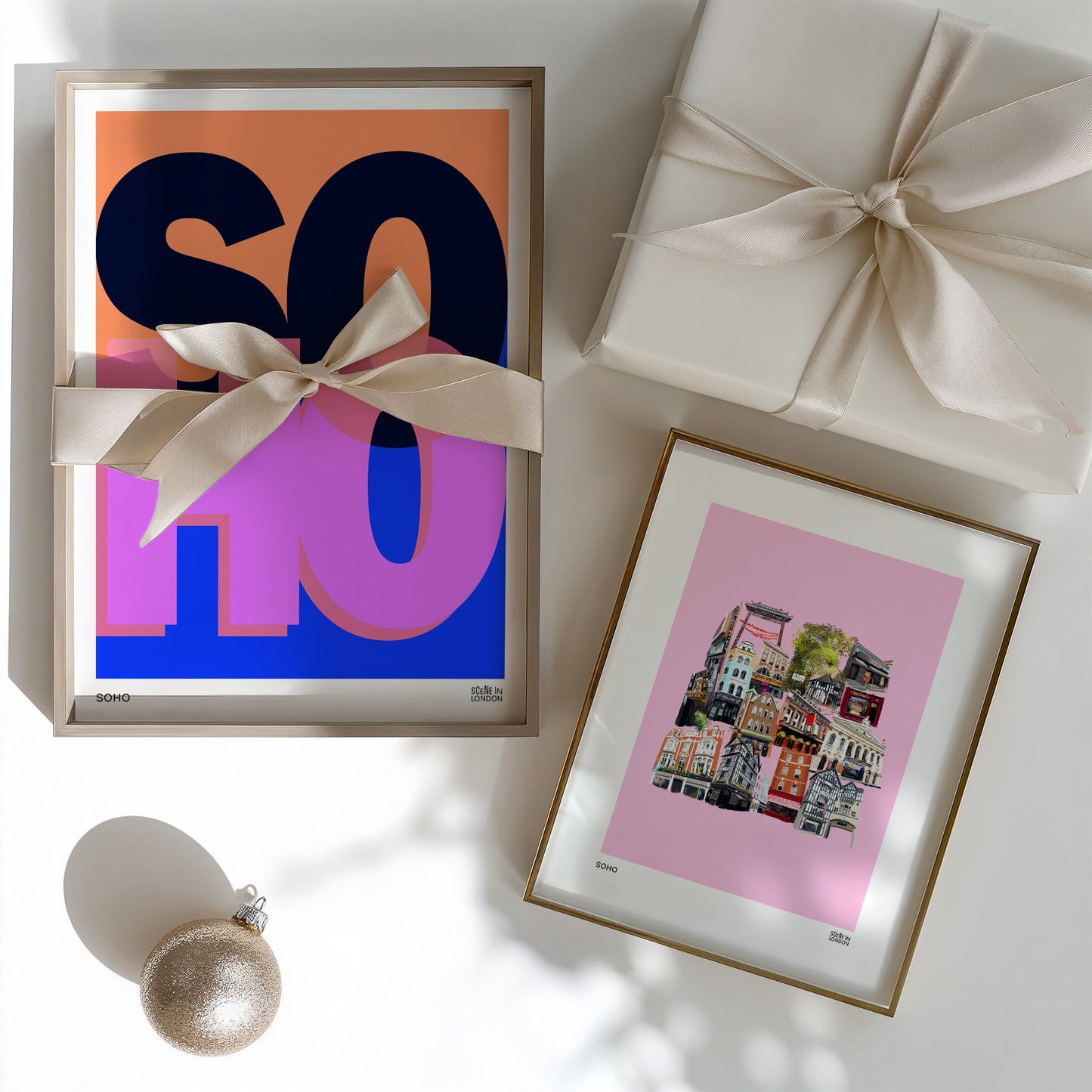 Soho art prints with a bow, gift box, and ornament on a light surface